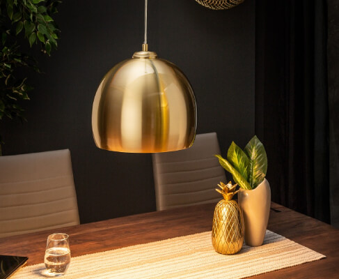 Oświetlenie kierunkowe - złota lampa wisząca nad stołem jadalnianym